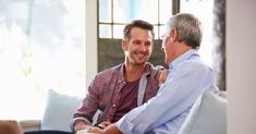 two men sitting on a couch talking to each other