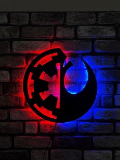 the star wars symbol is lit up on a brick wall with blue and red lights