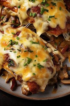 two pieces of chicken covered in cheese and mushrooms