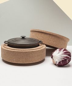 an onion sitting next to a pot on top of a table