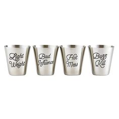 four silver shot glasses with black lettering on them