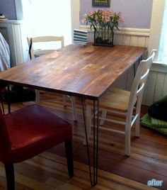 a wooden table sitting on top of a hard wood floor next to a red chair