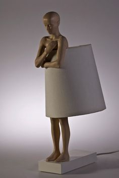 a lamp that is shaped like a human figure with a white shade on it's head