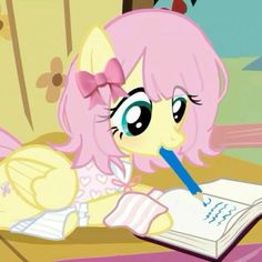 a pinkie sitting at a desk with a book and pen in her mouth,