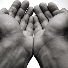 two hands holding something in the air with one hand extended up to the other, both on top of each other