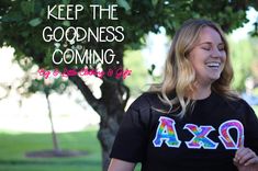 a woman is smiling while wearing a black shirt with the words axo on it