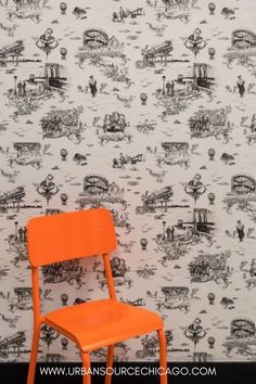 an orange chair sitting in front of a wall