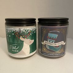 two jars with labels on them sitting next to each other in front of a white wall