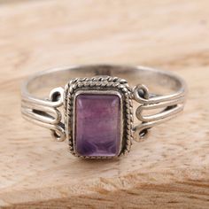 Framed in a braided motif, the translucent purple stone on Bhavya Jain's single stone ring is magical and mesmerizing. The Indian artisan uses sterling silver to hand craft the ring, centering its delicate band with a smooth amethyst gem in a bezel setting.