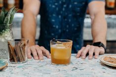 a man sitting at a table with a drink in front of him