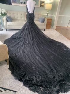 a black dress is on display in a room with white carpet and couches,