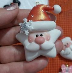 a hand holding a christmas ornament with santa clause on it's head