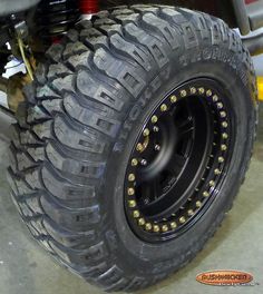 an off road truck tire with gold rivets on it's tires is shown