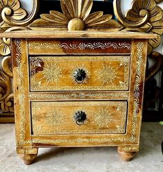 an ornately decorated chest of drawers with gold paint on the top and bottom drawer