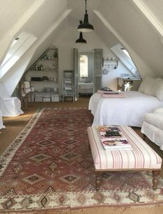 an attic bedroom with two beds and a large rug