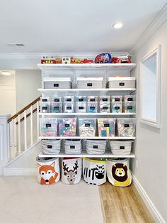 an organized closet with bins, baskets and stuffed animals on the bottom shelf for storage