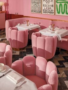 the interior of a restaurant with pink chairs and tables