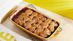 a yellow dish filled with blueberry cobbler on top of a counter