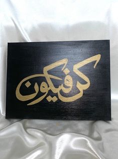 arabic calligraphy on black and gold painted wood