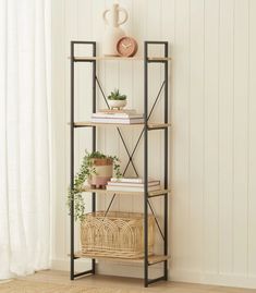 a shelf with books and plants on it in front of a white wall next to a window