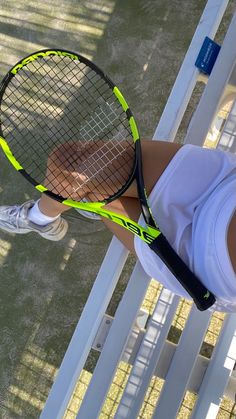 a young woman holding a tennis racquet on top of a tennis ball court