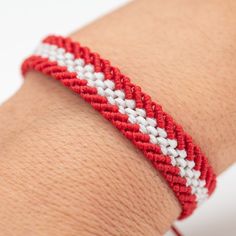 a red and white bracelet on someone's arm