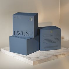 two blue boxes sitting on top of a marble counter next to each other with the word lavine printed on them