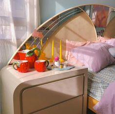 a bed room with a neatly made bed and some cups on the dresser next to it