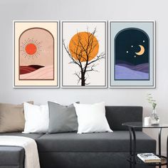 three paintings hang on the wall above a couch in a living room with a table and chair