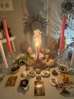 a table topped with lots of different types of candles and pictures on top of it