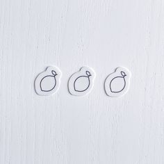 three buttons with the shape of an egg and two smaller ones are on a white surface