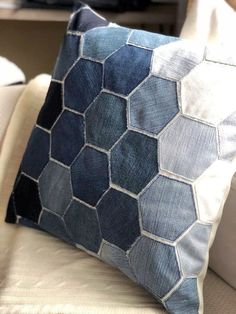 a blue and white pillow sitting on top of a couch