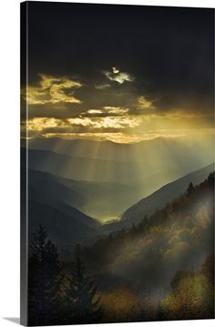 the sun shines through the clouds in this mountain scene with mountains and trees on either side