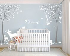 a baby's room with a crib and wall decals