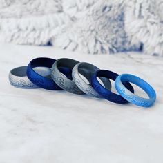 four different colored rings sitting on top of a snow covered ground