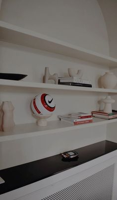 a shelf with books and vases on it