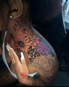 a woman with tattoos on her chest and hand in front of her face, holding onto the back of her neck