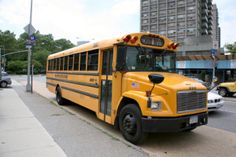 a yellow school bus is parked on the side of the street