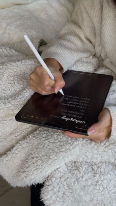 a person holding a tablet with a pen in their hand