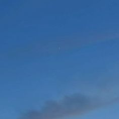 a man flying a kite in the sky on a clear day with no one around