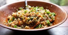 a brown bowl filled with rice and vegetables