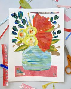 an art project with watercolors and paper flowers in a vase on a table