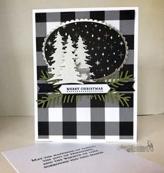 a black and white christmas card with pine trees