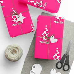 pink wrapping paper with hearts and stars on it next to twine of twine