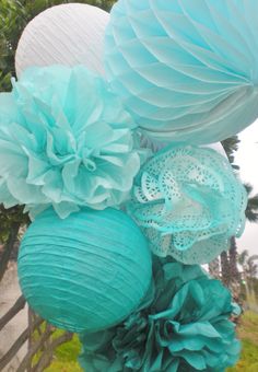 some blue paper flowers are hanging from a pole