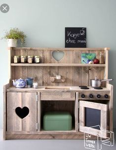 a wooden toy kitchen with pots and pans on the stove top, next to a chalkboard sign that says knick knack