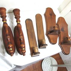 several wooden objects are sitting on a white tablecloth and one is being used as a coat rack