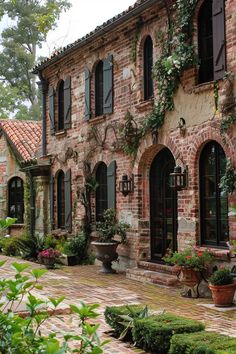 an old brick building with potted plants on the outside