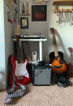 guitars, amps and other musical equipment are on the floor in front of a wall