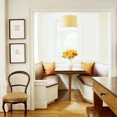 a dining room table with two chairs and a bench in front of it, next to a window